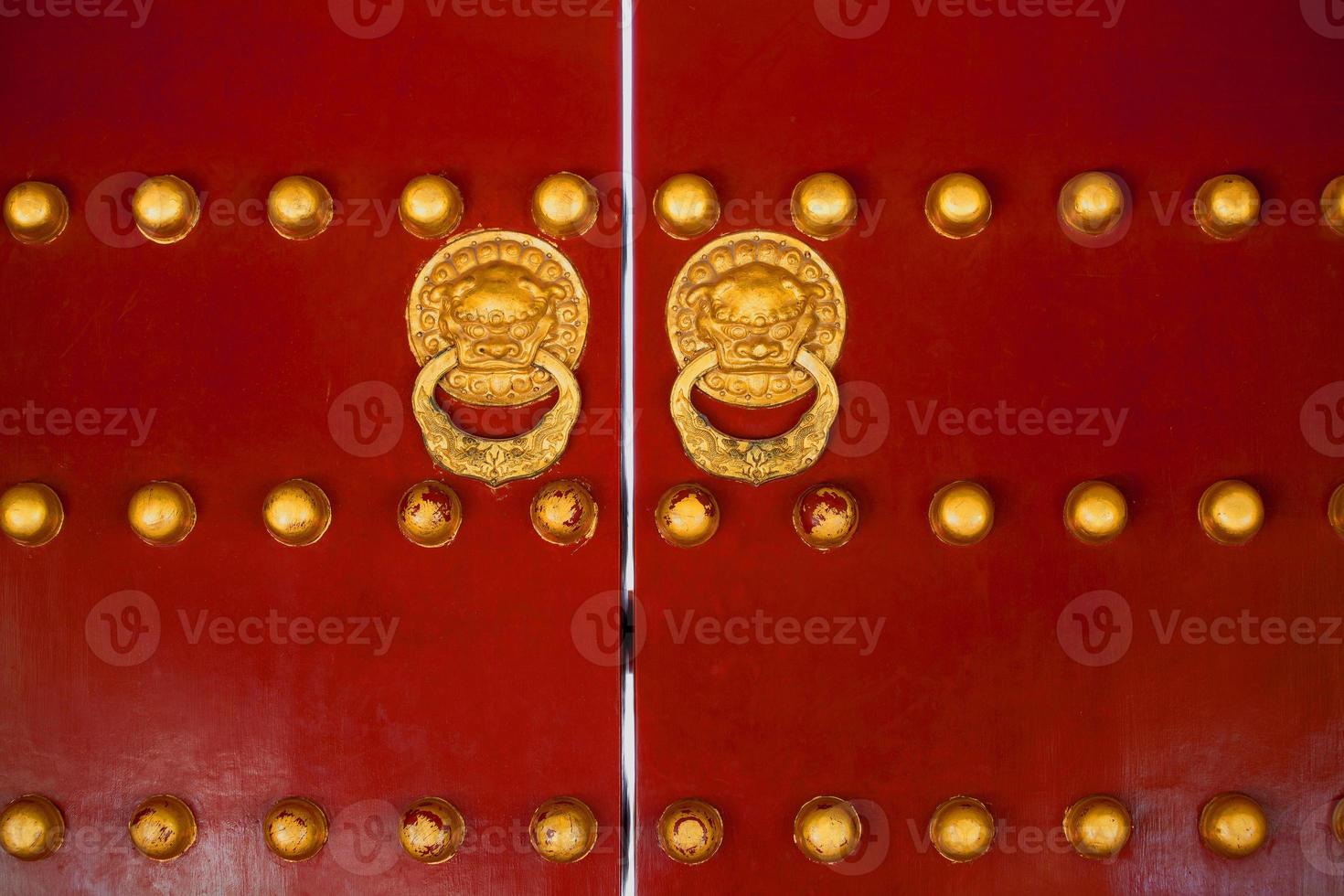 Chinese gate red doors with golden dragon heads knockers photo