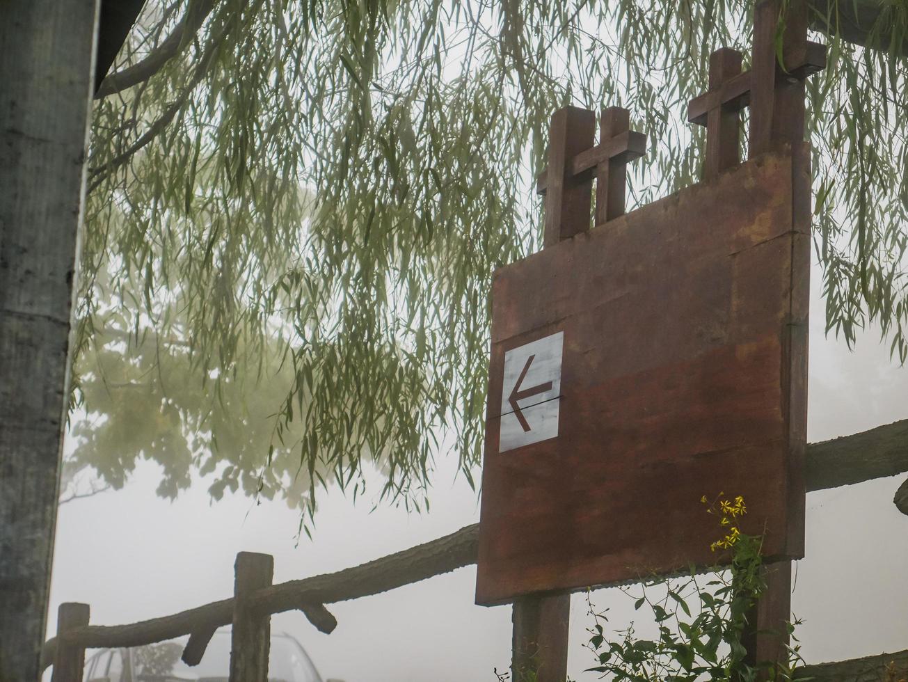 poste de guía de madera en blanco en día de niebla foto