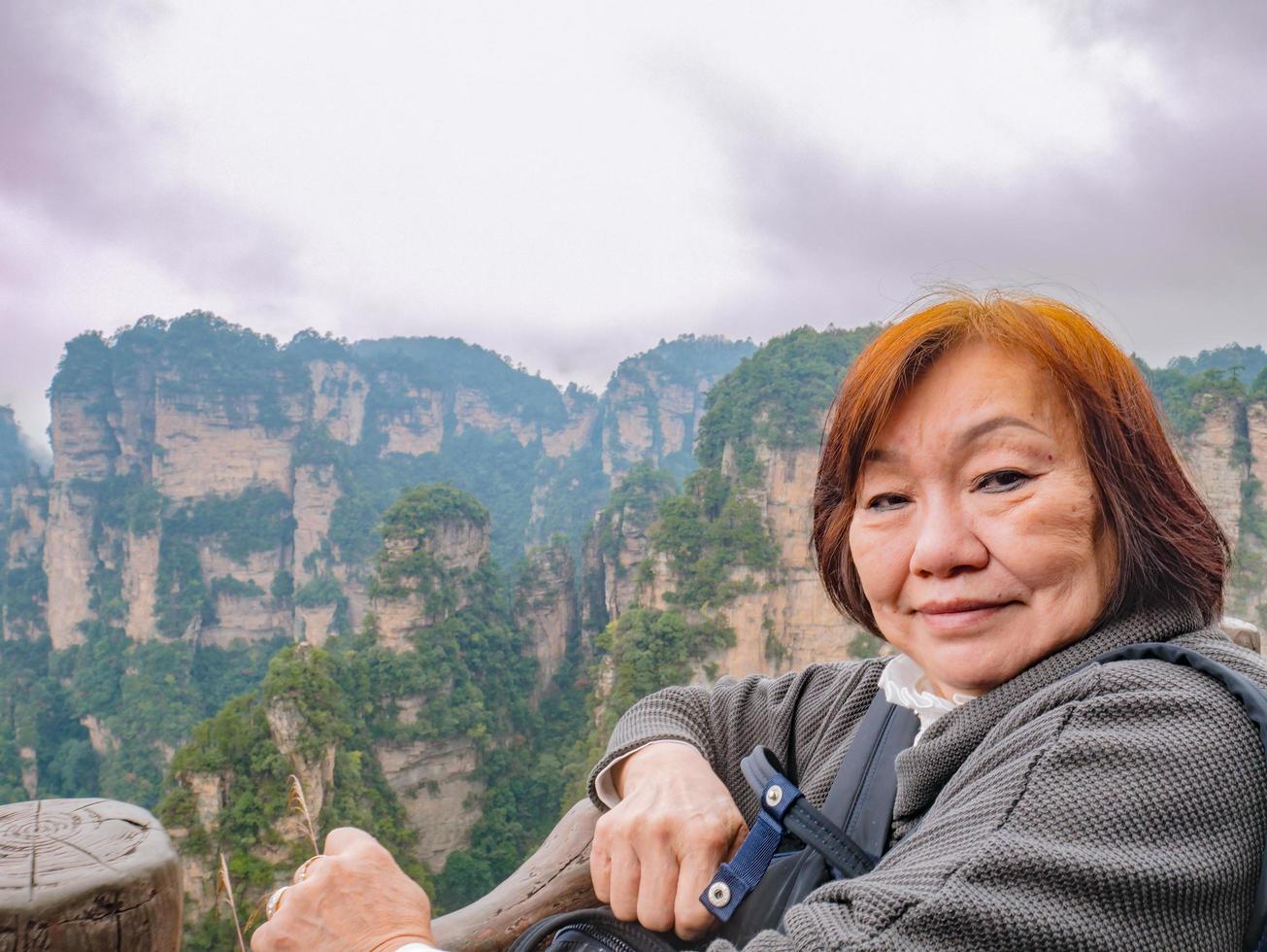 Portrait photo of Senior asian women with Beautiful mountain of Yuanjiajie or Avartar mountain at Zhangjiajie National Forest Park in Wulingyuan District Zhangjiajie City China