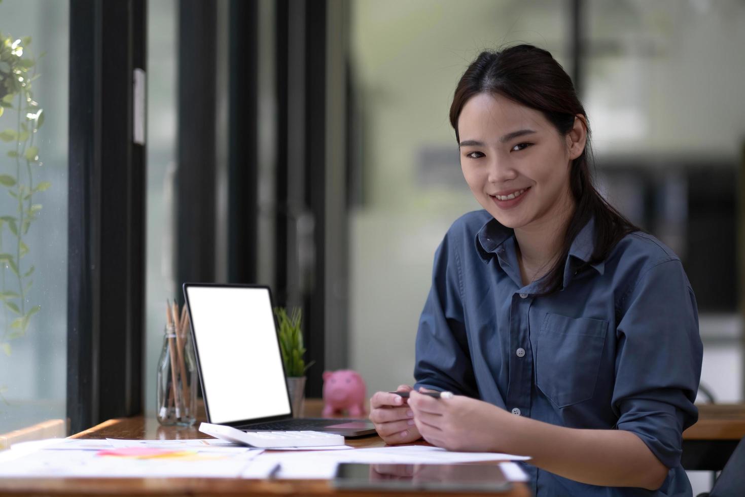 Shot of a asian young business Female working on laptop computer in her workstation.Portrait of Business people employee freelance online marketing e-commerce telemarketing concept. photo