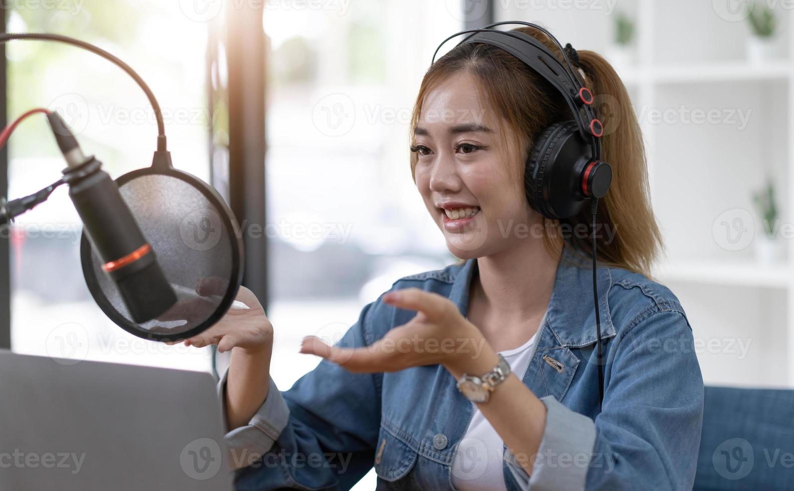 Beautiful asian young woman radio host working, setting microphone, preparing to speak before recording podcast and live on social media. Technology of on-air online in broadcasting at home studio. photo