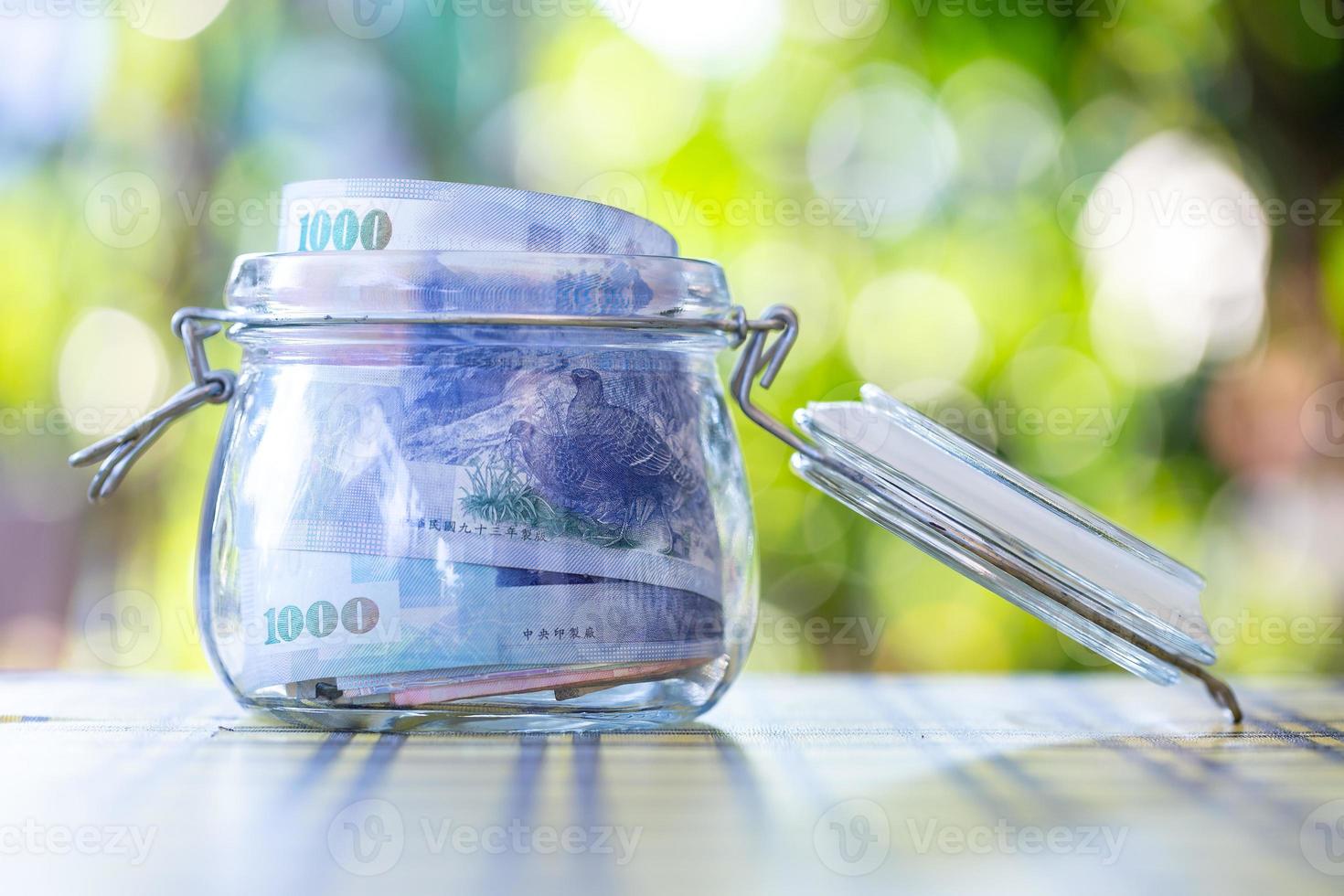 Taiwan banknotes in glass jar. photo