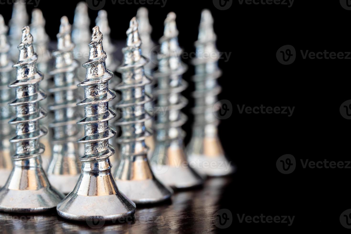 Close up of screws on a black background. Advertising photo. Selective focus photo