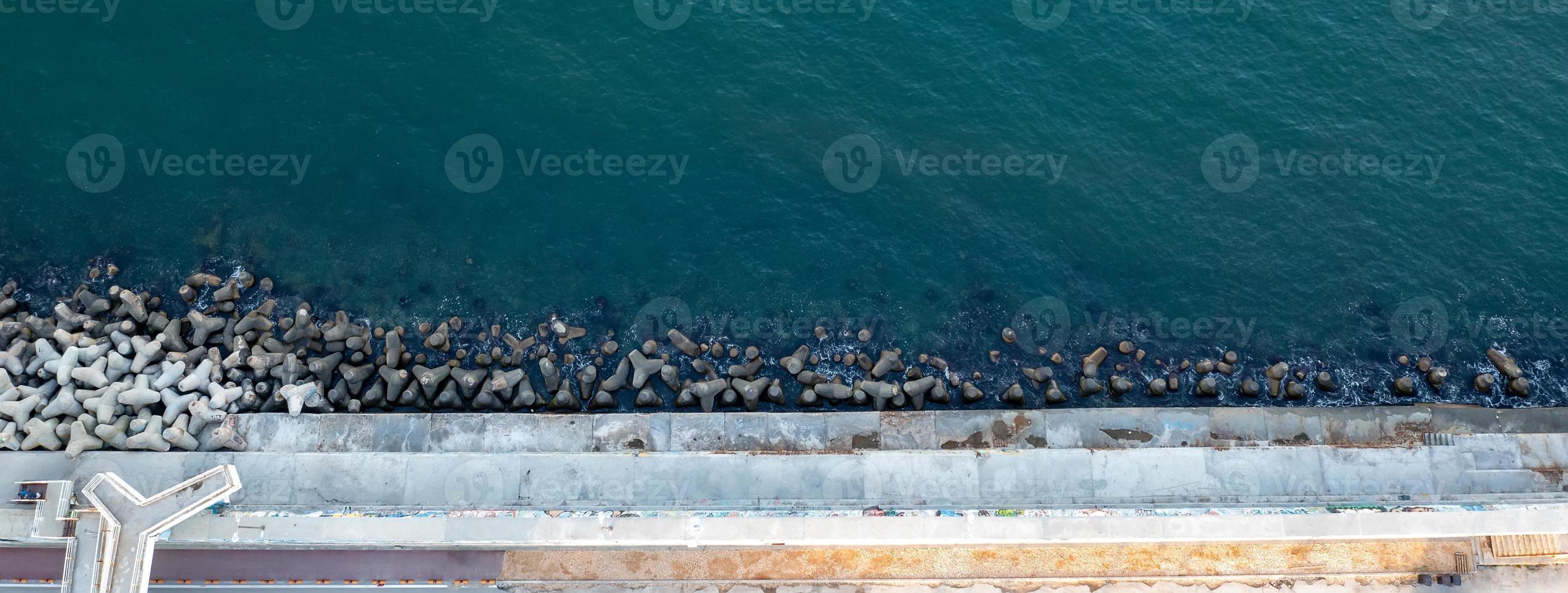 Aerial top view from drone to the seacoast and  concrete pier photo