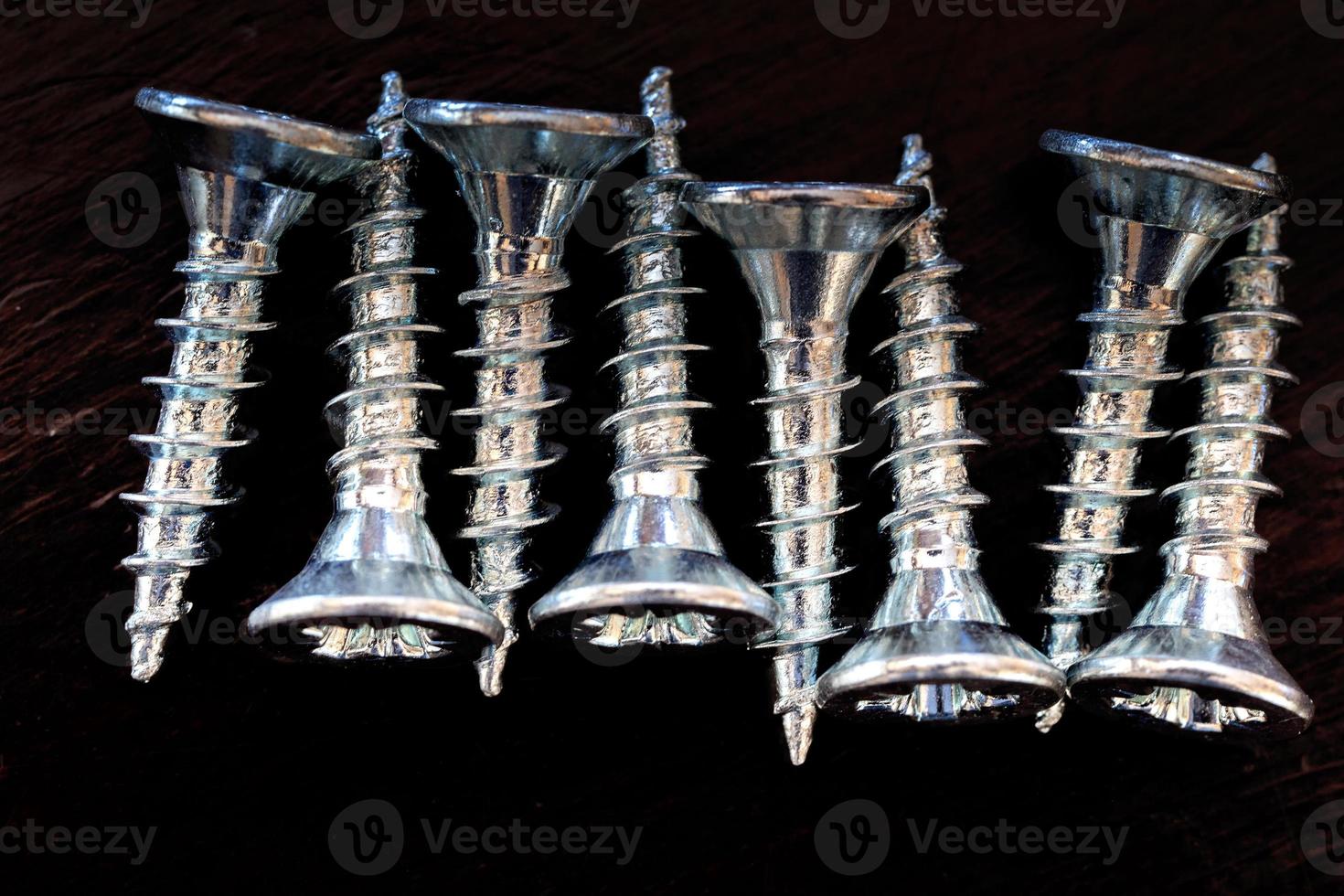 Top view of screws on a black background. photo