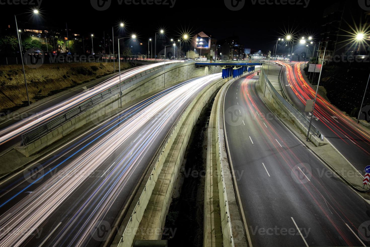 carretera de cruce de tráfico nocturno con luces de movimiento de vehículos. vista horizontal foto