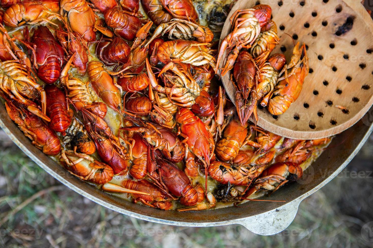 Boiled red crayfish or crawfish with herbs. Crayfish boiling in the pot on the fire photo