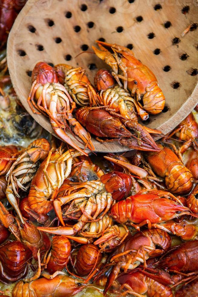 Boiled red crayfish or crawfish with herbs. Crayfish boiling in the pot on the fire photo