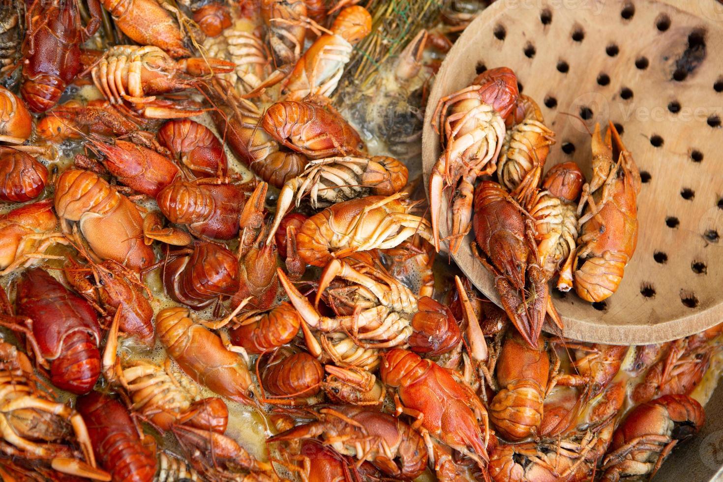 Boiled red crayfish or crawfish with herbs. Crayfish boiling in the pot on the fire photo