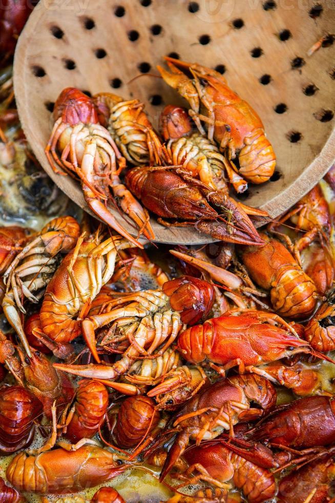 Boiled red crayfish or crawfish with herbs. Crayfish boiling in the pot on the fire photo