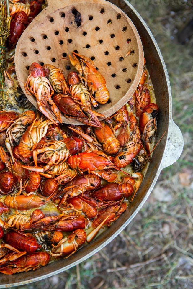 Boiled red crayfish or crawfish with herbs. Crayfish boiling in the pot on the fire photo