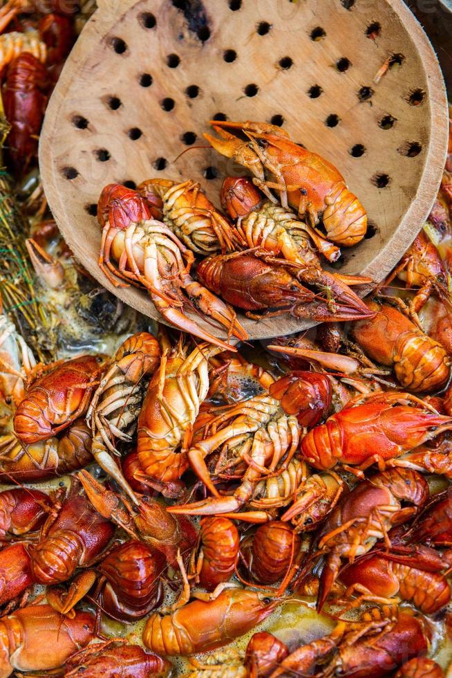 Boiled red crayfish or crawfish with herbs. Crayfish boiling in the pot on the fire photo