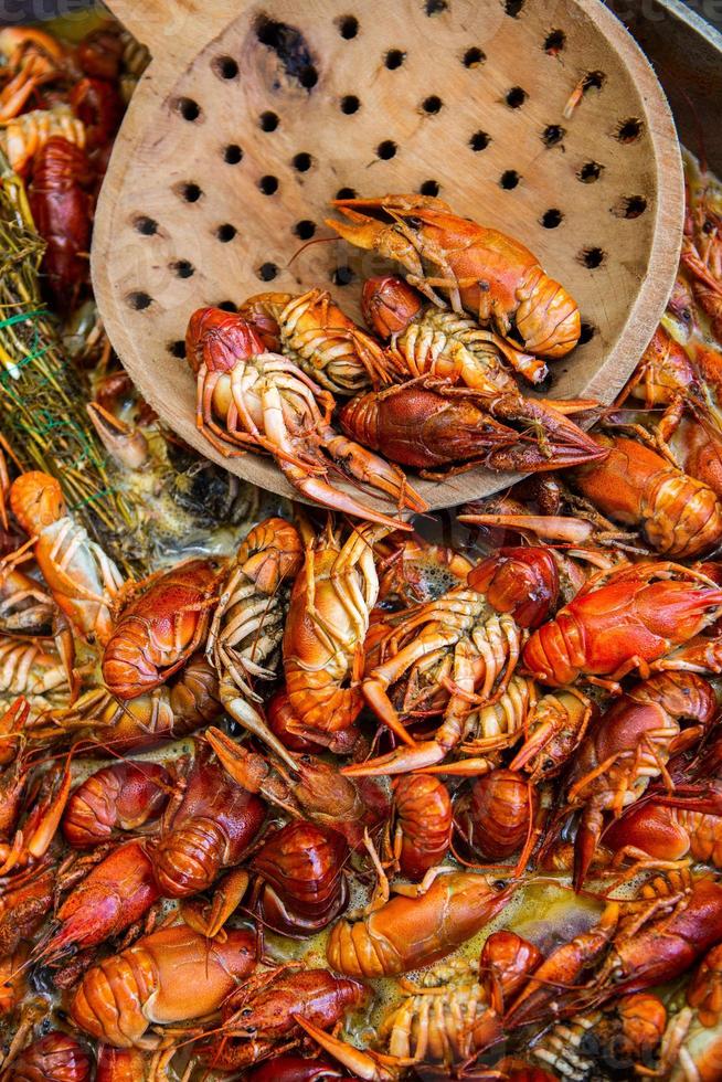 Boiled red crayfish or crawfish with herbs. Crayfish boiling in the pot on the fire photo