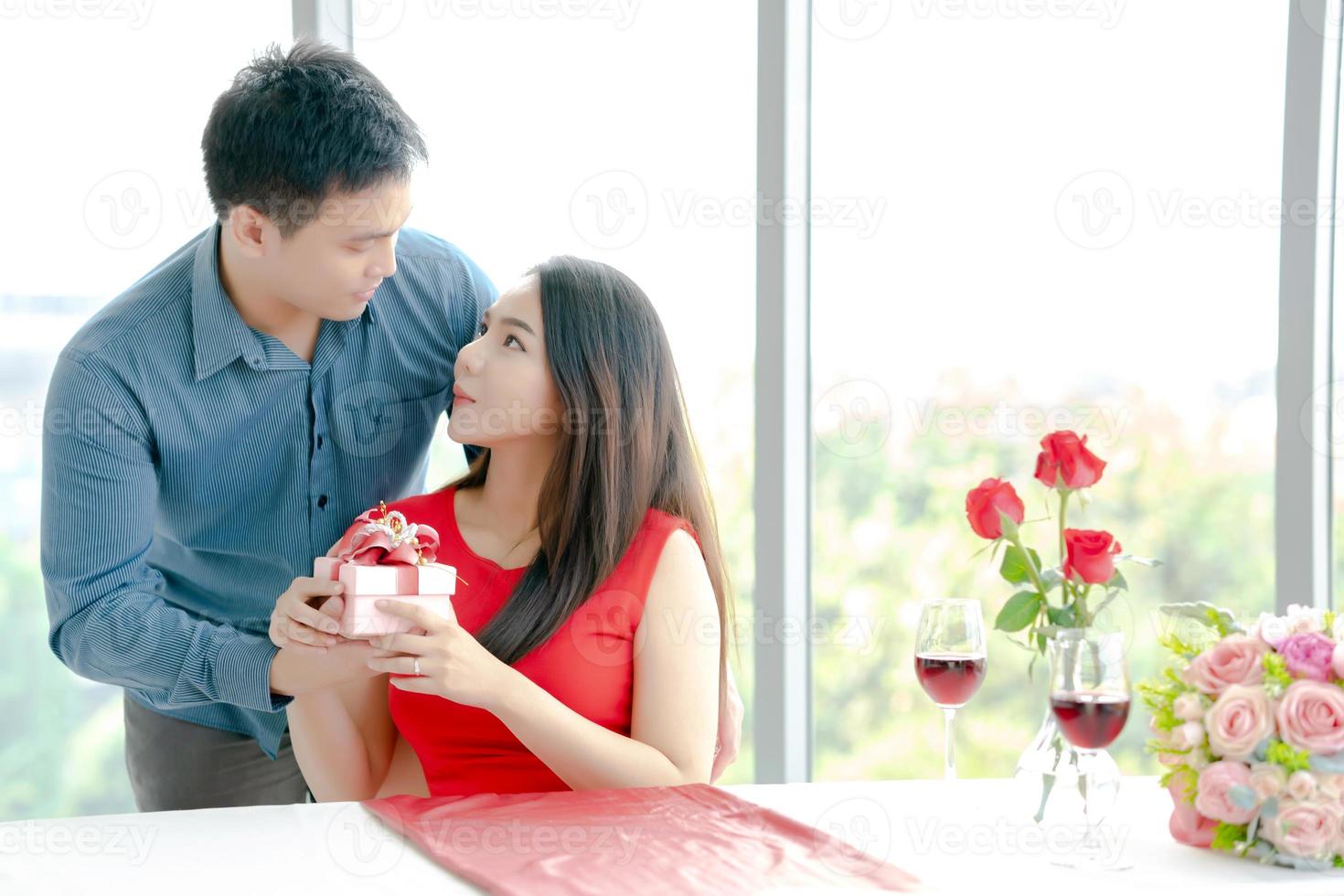 Man giving his girlfriend gift box with red ribbon photo