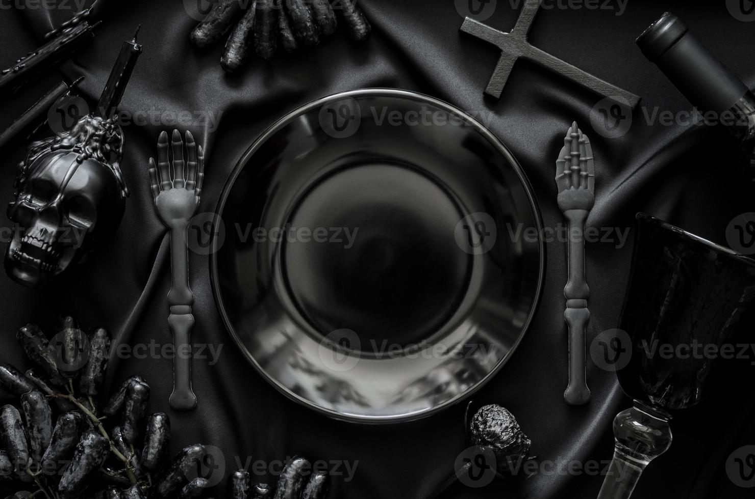Halloween dinner party concept with black accessories, a bottle and glass of wine and grape fruits put on cloth background. photo