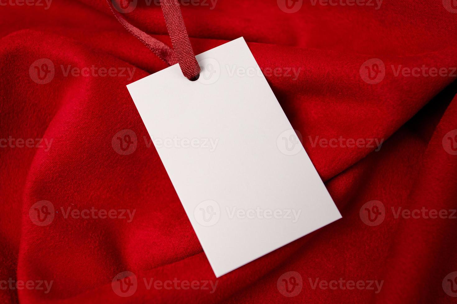 Modern advertising for cloth design. Clothes tag mock up white on red fabric. Modern design. Red fabric pattern background. Price tag. photo