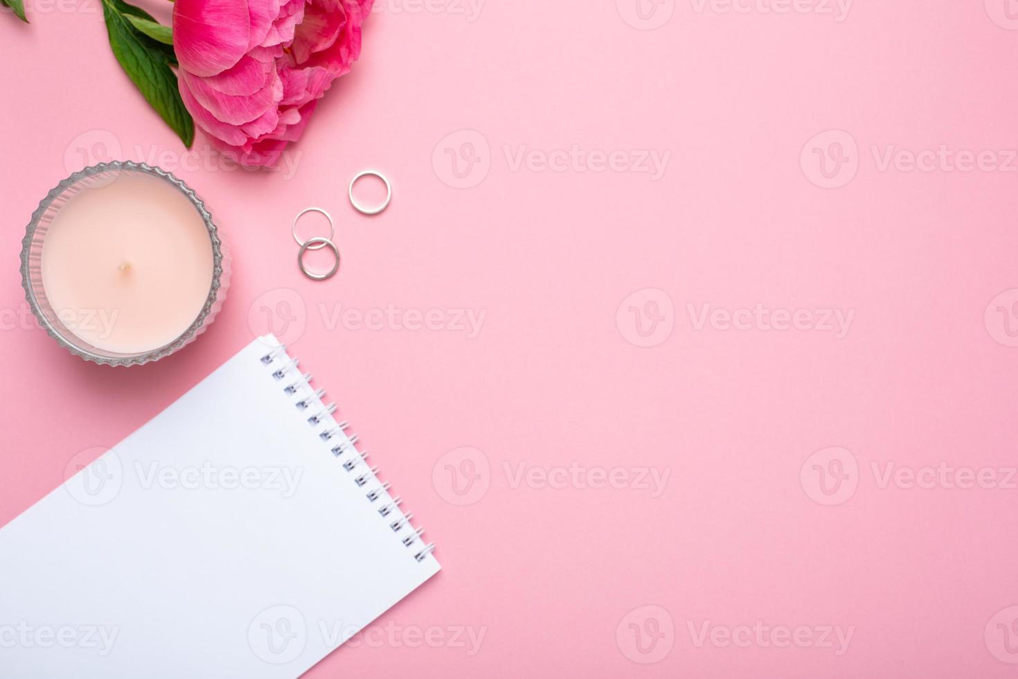 Beautiful pink peony flower and notebook with copy space for your text on pastel pink background photo