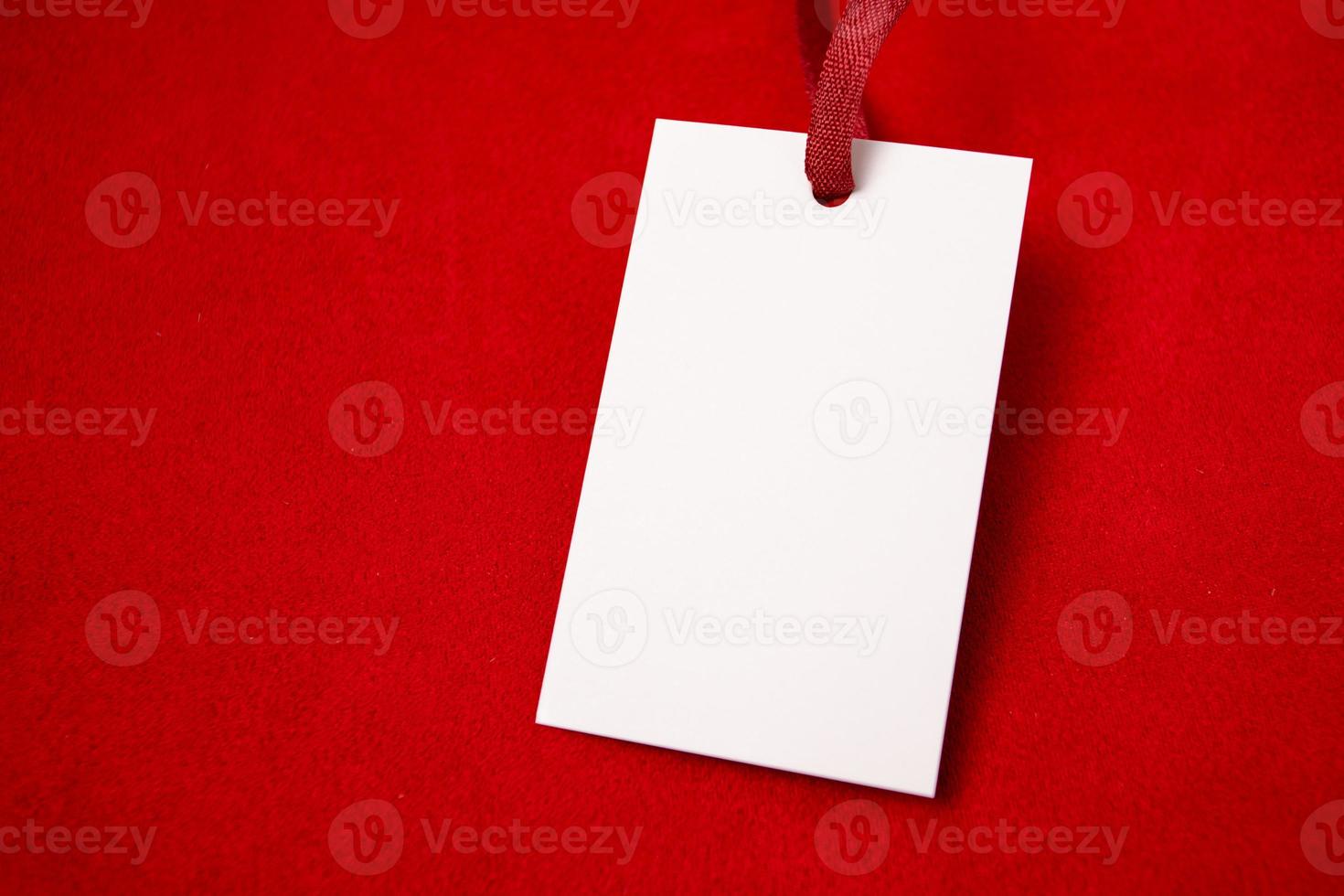 Modern advertising for cloth design. Clothes tag mock up white on red fabric. Modern design. Red fabric pattern background. Price tag. photo