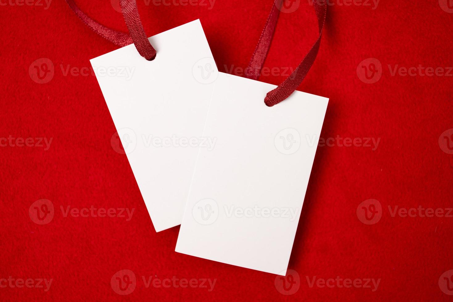 Modern advertising for cloth design. Clothes tag mock up white on red fabric. Modern design. Red fabric pattern background. Price tag. photo