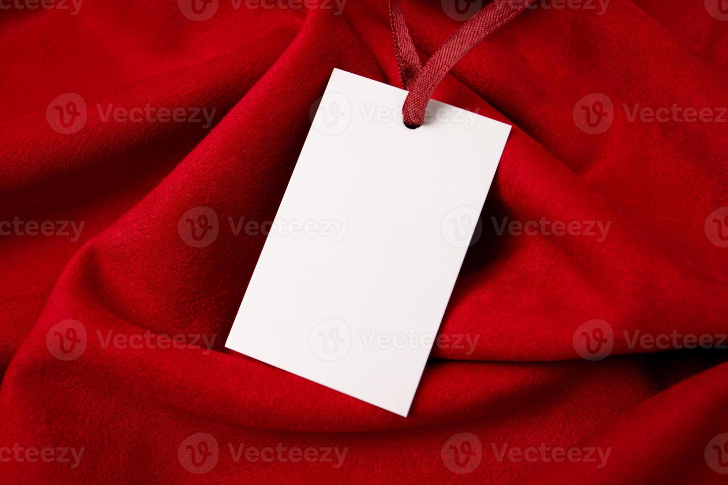 Modern advertising for cloth design. Clothes tag mock up white on red fabric. Modern design. Red fabric pattern background. Price tag. photo