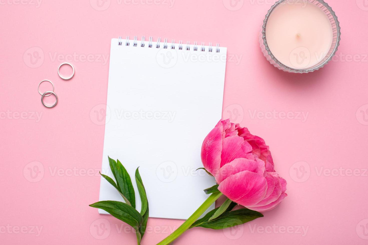 Beautiful pink peony flower and notebook with copy space for your text on pastel pink background photo