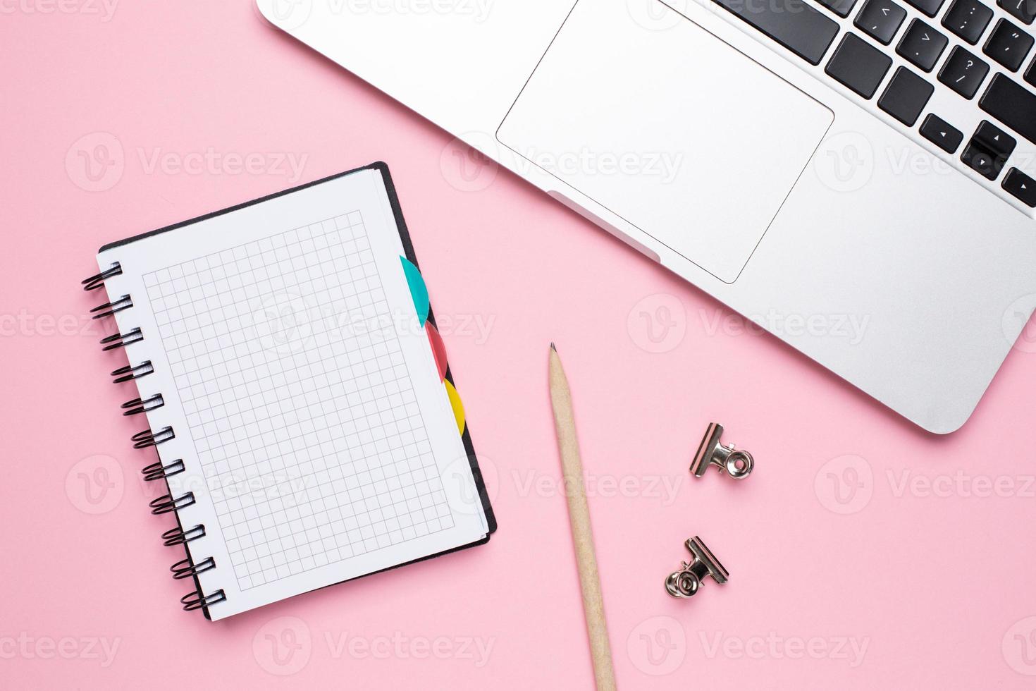 Notebook and laptop on a pink background photo