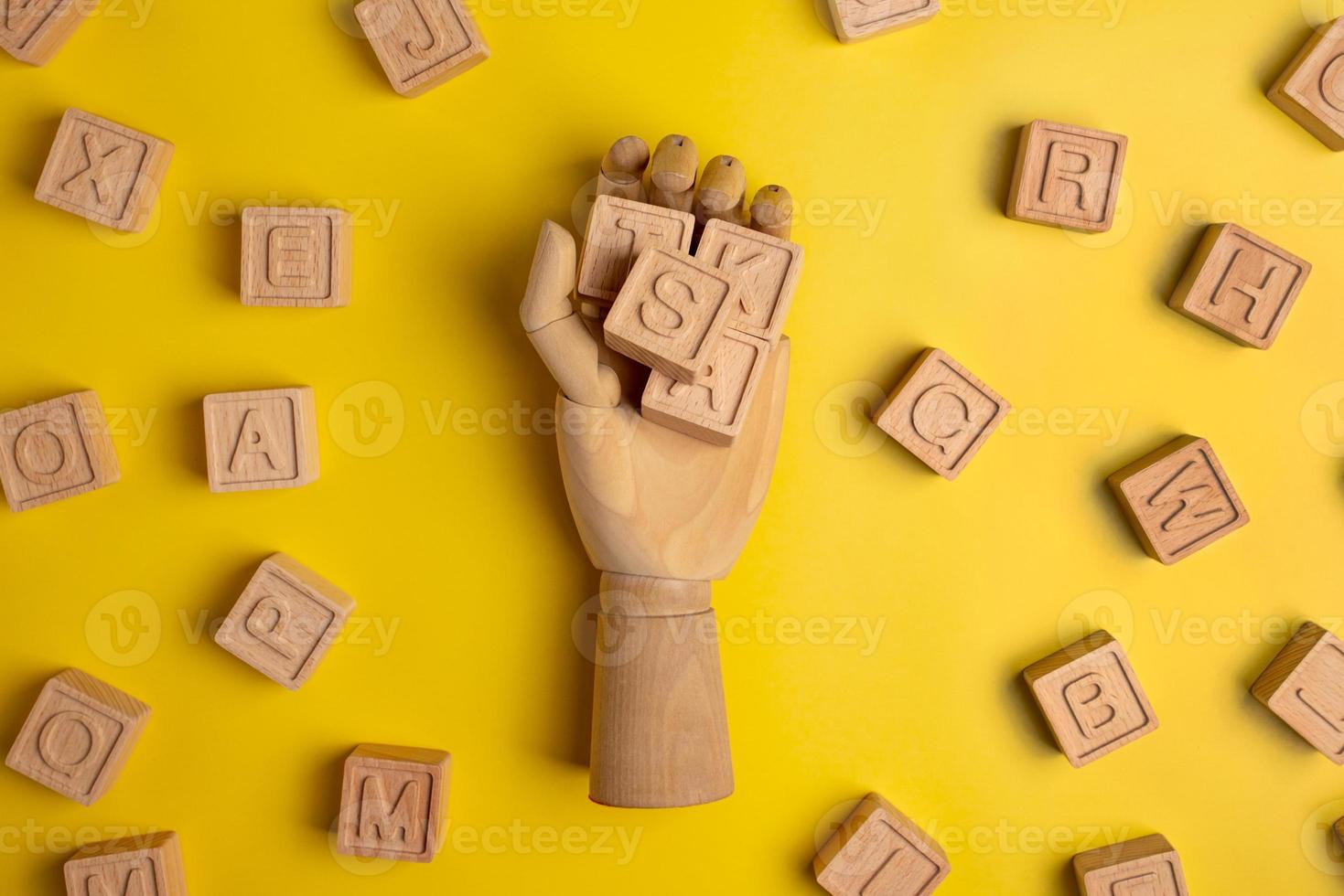 Wooden cubs with letters for words in wood hand on yellow background. Business and study concept photo