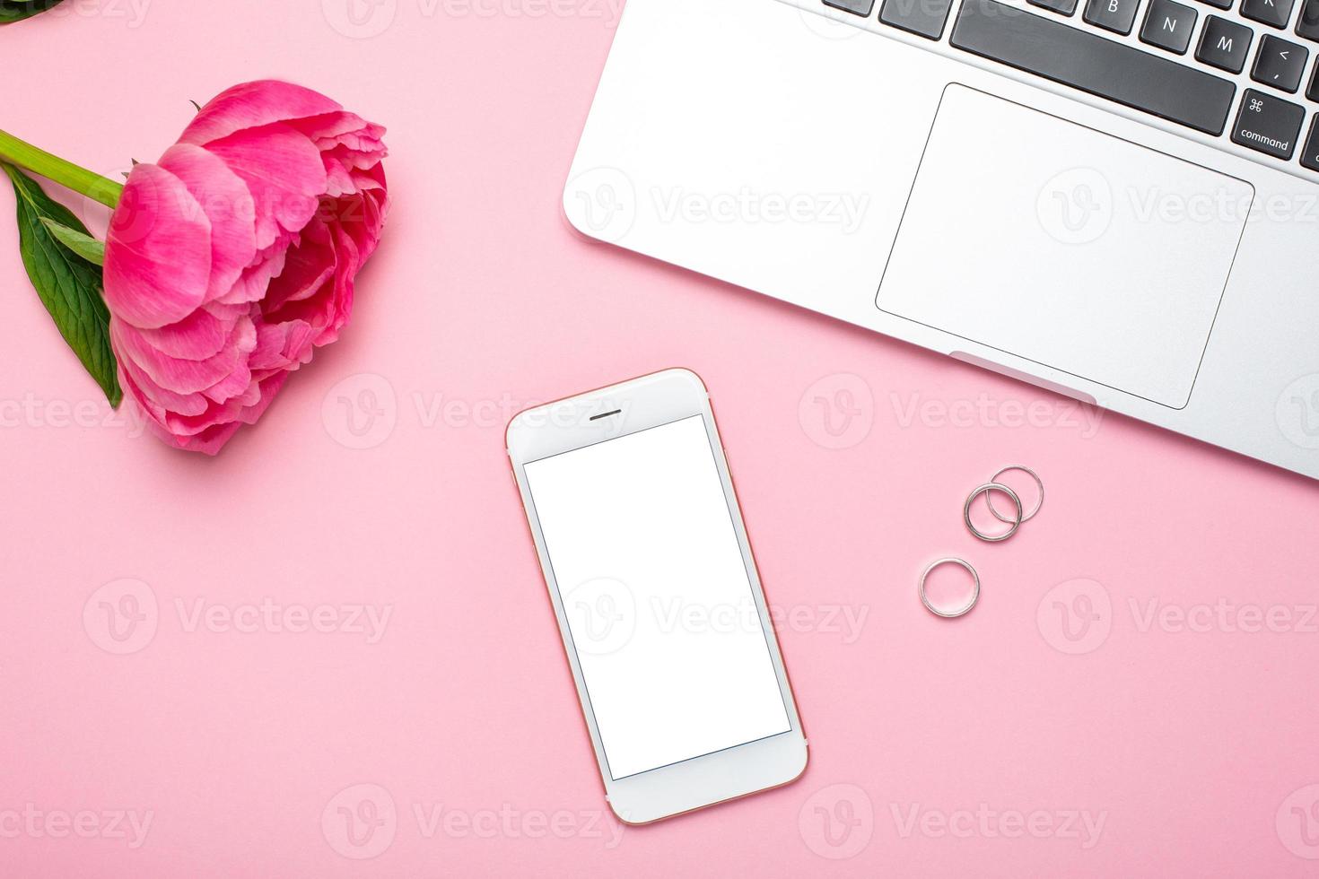 Mobile phone mock up and peony flower on pink pastel table in flat lay style. Woman working desk.Summer colour photo