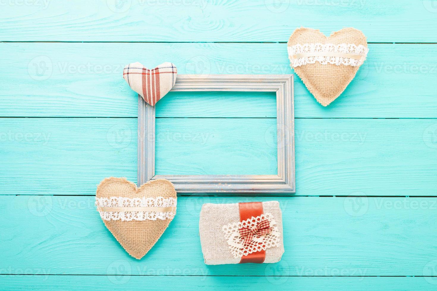 Romantic frame with copy space and accessories on blue wooden background. Top view photo