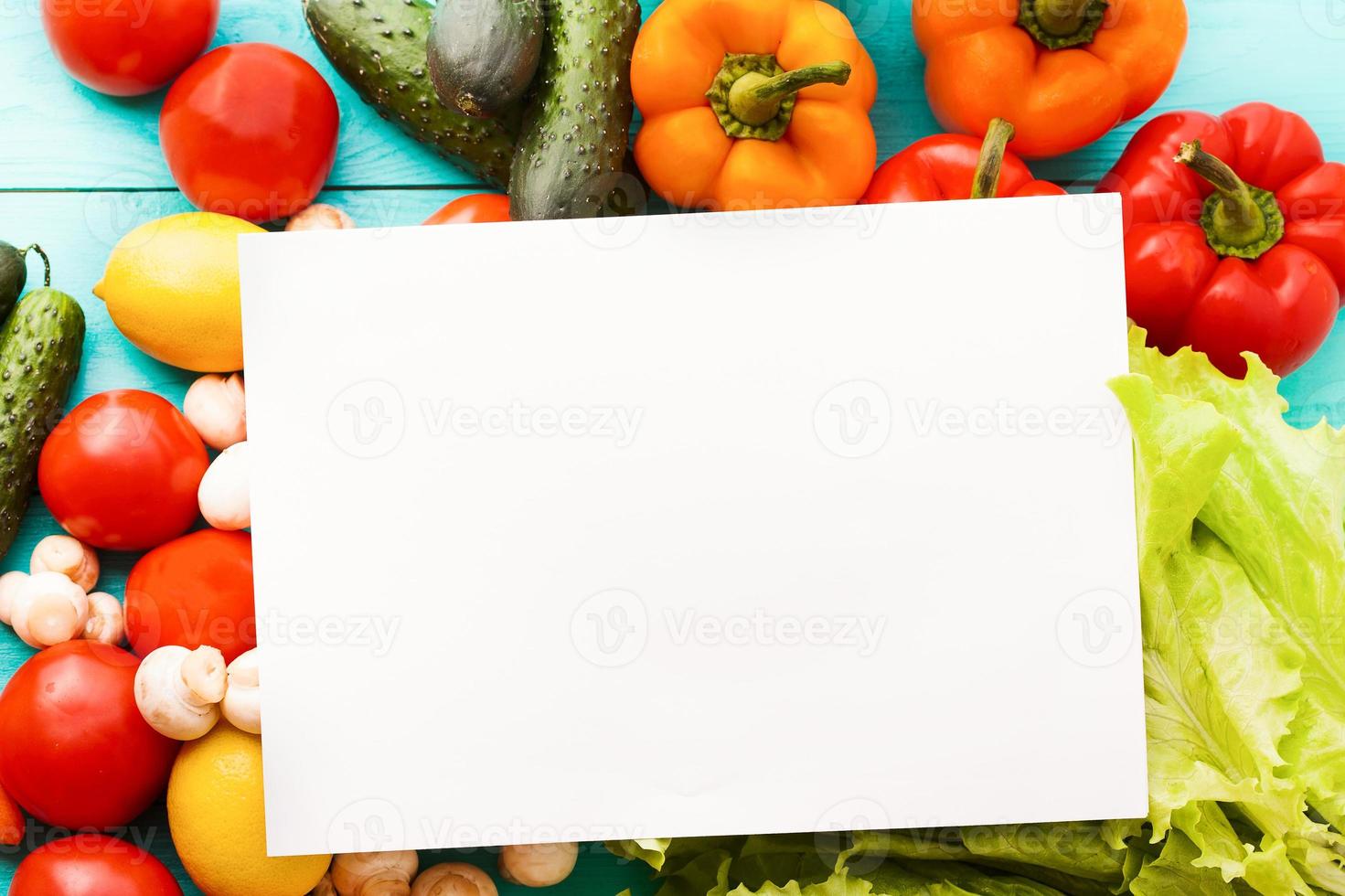 Recipe paper with vegetables on blue table. Top view photo