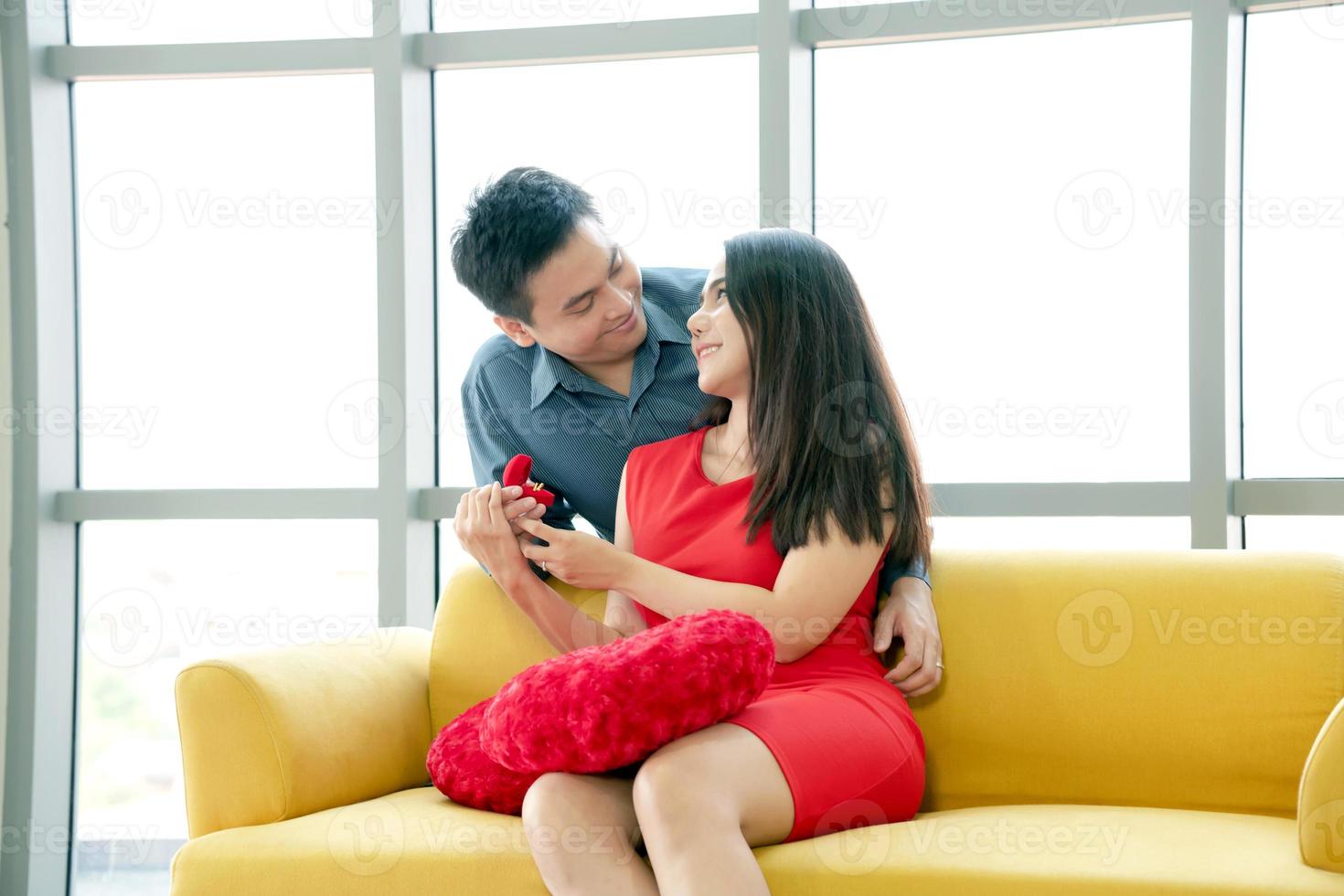 Happy young woman receiving engagement ring from her boyfriend photo