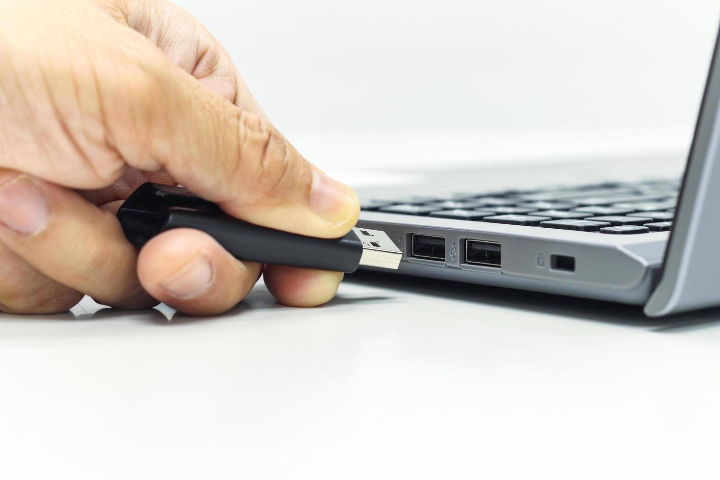 Hand of Businessman push the USB Drive to USB Port for Laptop transfer data or save data photo