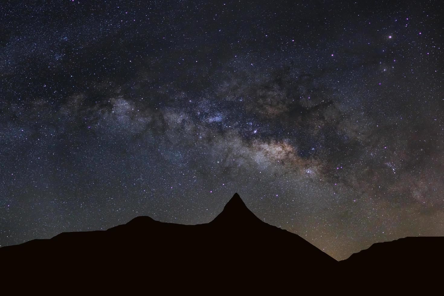 Starry night sky with high moutain and milky way galaxy with stars and space dust in the universe photo