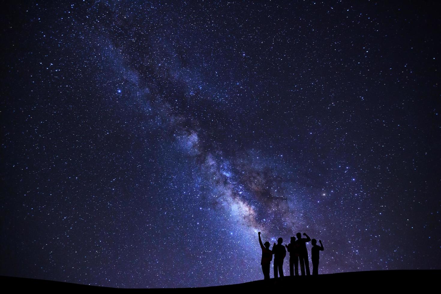 Landscape with milky way galaxy, Starry night sky with stars and silhouette of people standing happy man on high mountain. photo