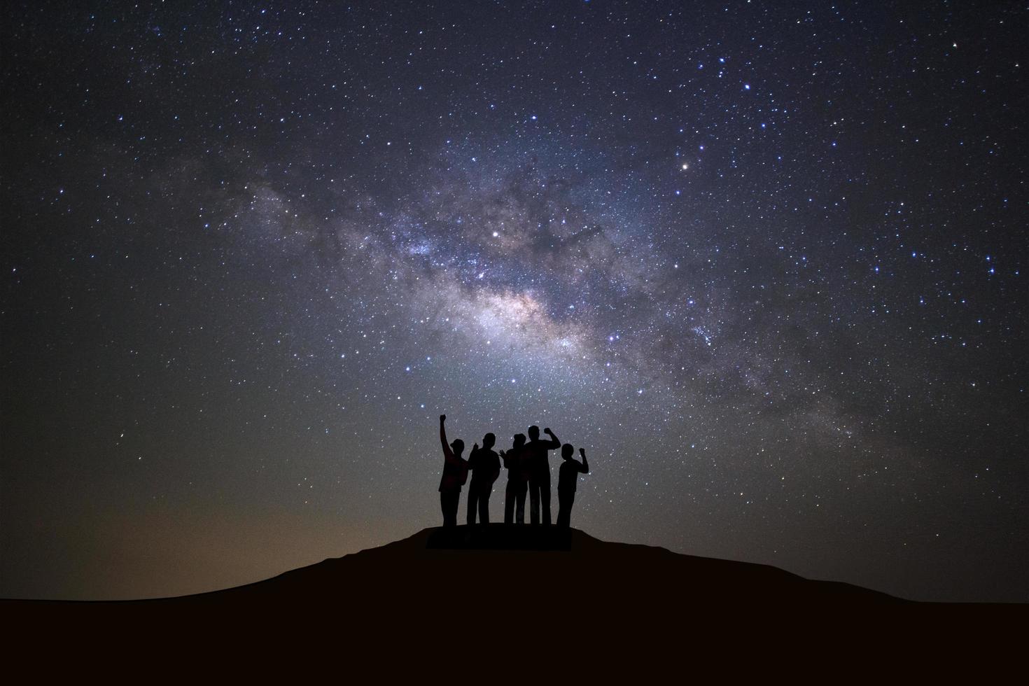 paisaje con galaxia de la vía láctea, cielo nocturno estrellado con estrellas y silueta de personas de pie hombre feliz en alta montaña. foto