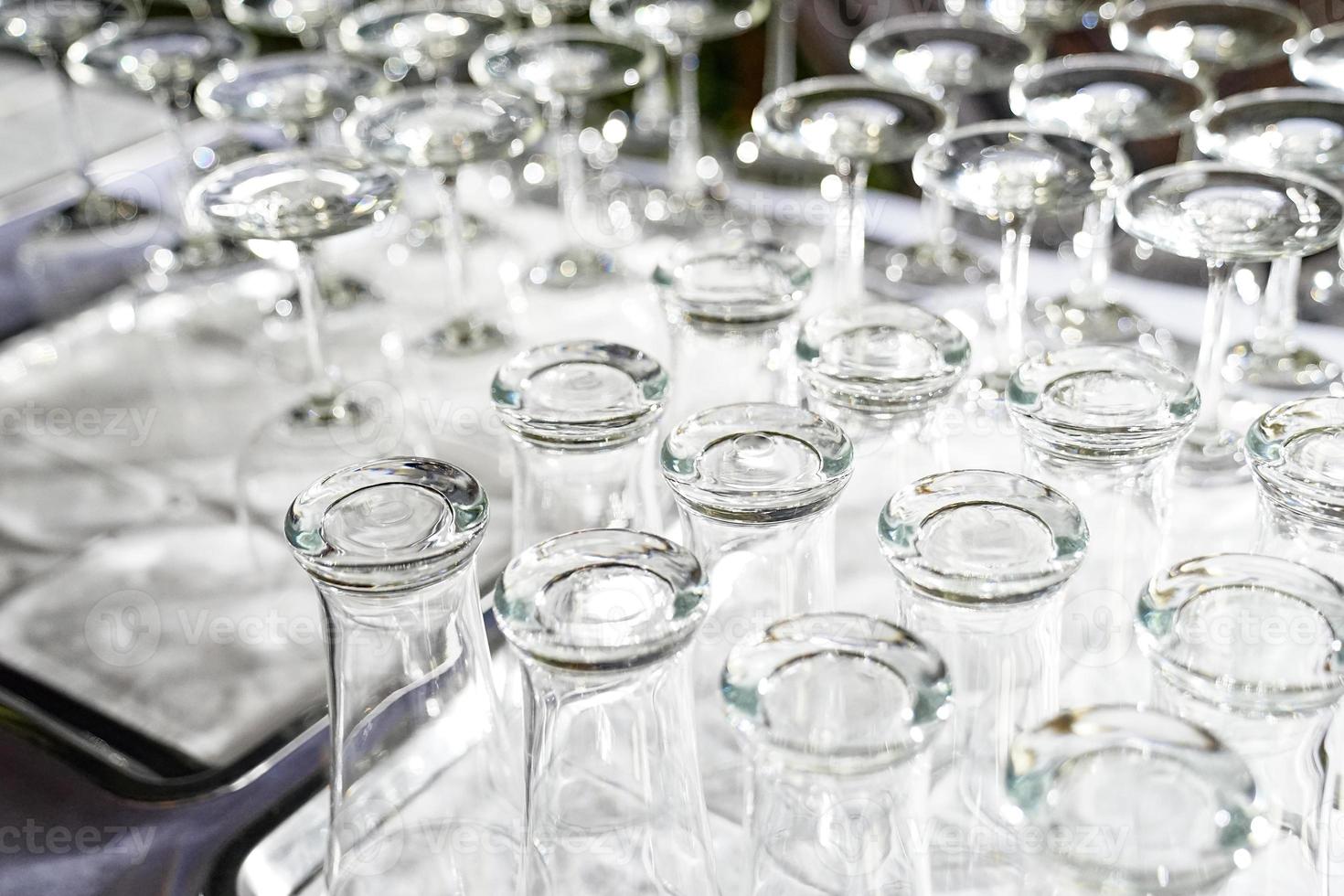 Wine glass and high glass are upside down on the white table in dinner time and ready to use. photo