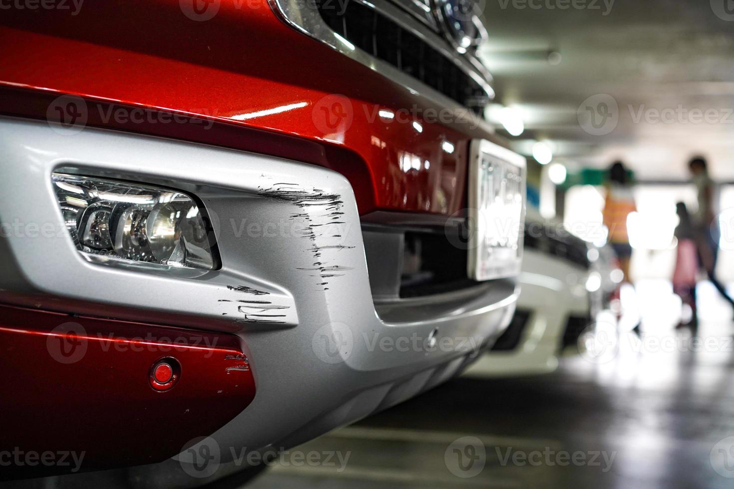Close up New Scratch damage on the front of New red car. photo