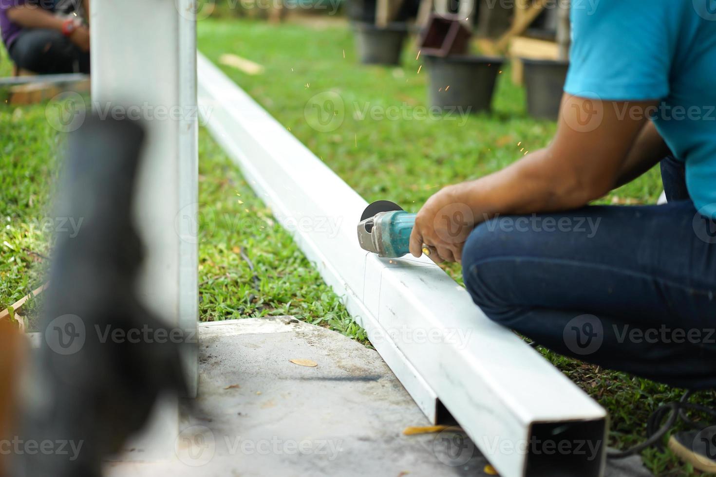 Asian smith are sawing the steel pole. photo