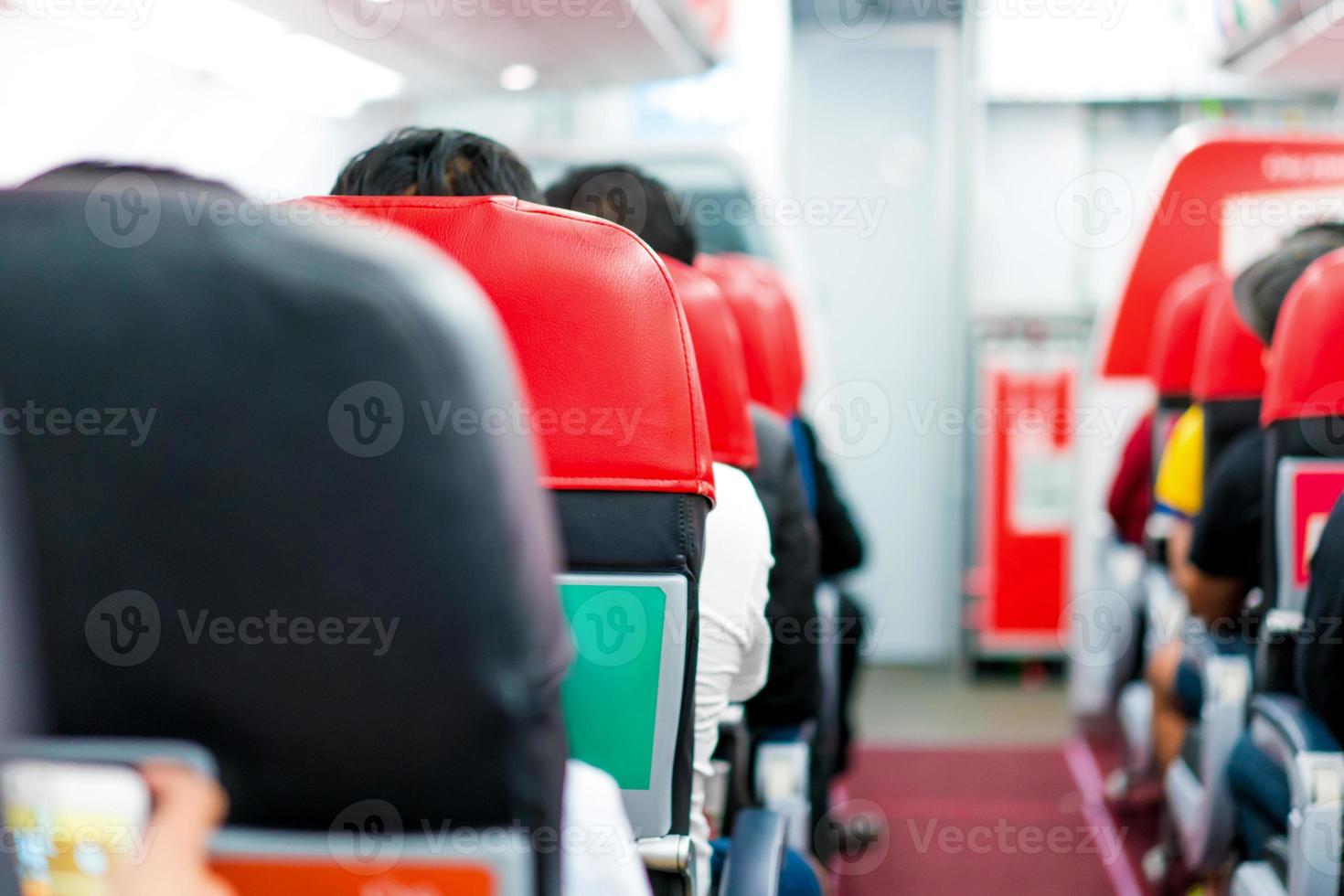 seats in the airplane and passenger sitting all area waiting for the plane taking off from runway. photo