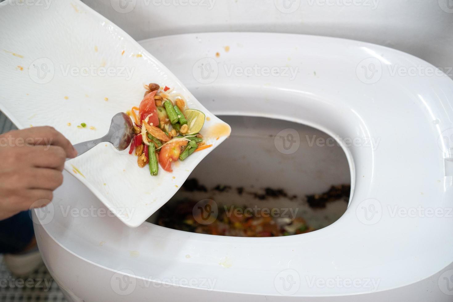 Asian woman seperated food in her white dish to composted hitech machine to feed microorganism inside for create good fertilizer to plantation. photo