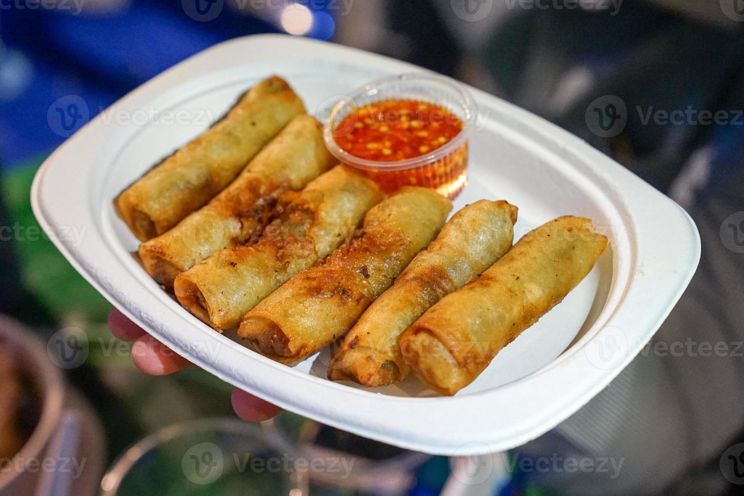 crispy spring rolls on the paper dish in the food truck and food street event, Bangkok, Thailand, Asia. photo