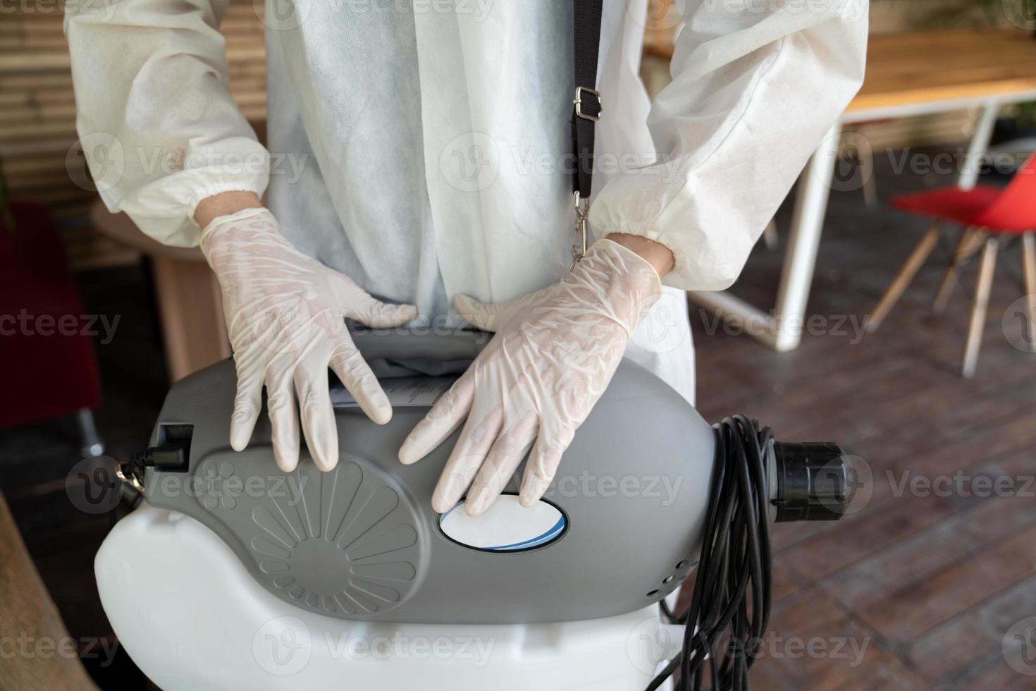 sterilizing machine water spray is standing by and ready to use from professional staff with prevention suit and rubber gloves to prevent and protect the coronavirus COVID19. photo