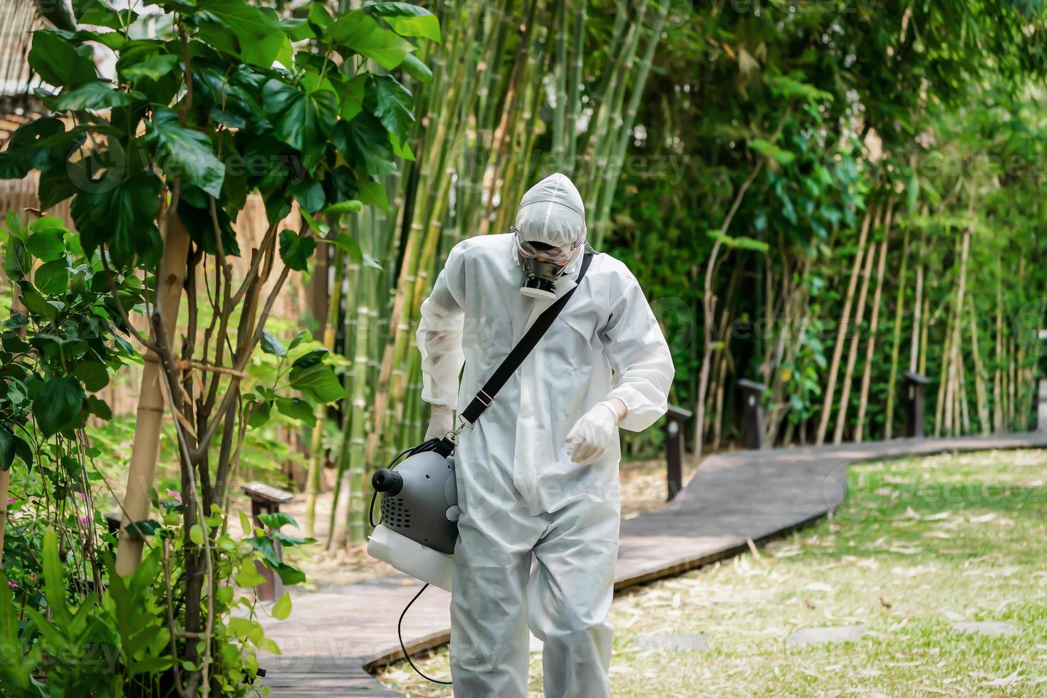 Professional specialist walking and observating around the outdoor garden to prepare spraying sanitizer liquid solution for kill Coronavirus COVID 19. photo