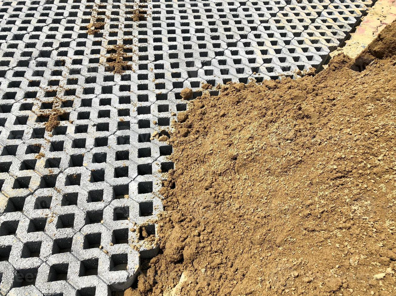 gray color stone brick block floor tile with green grass and sand as background or texture. photo