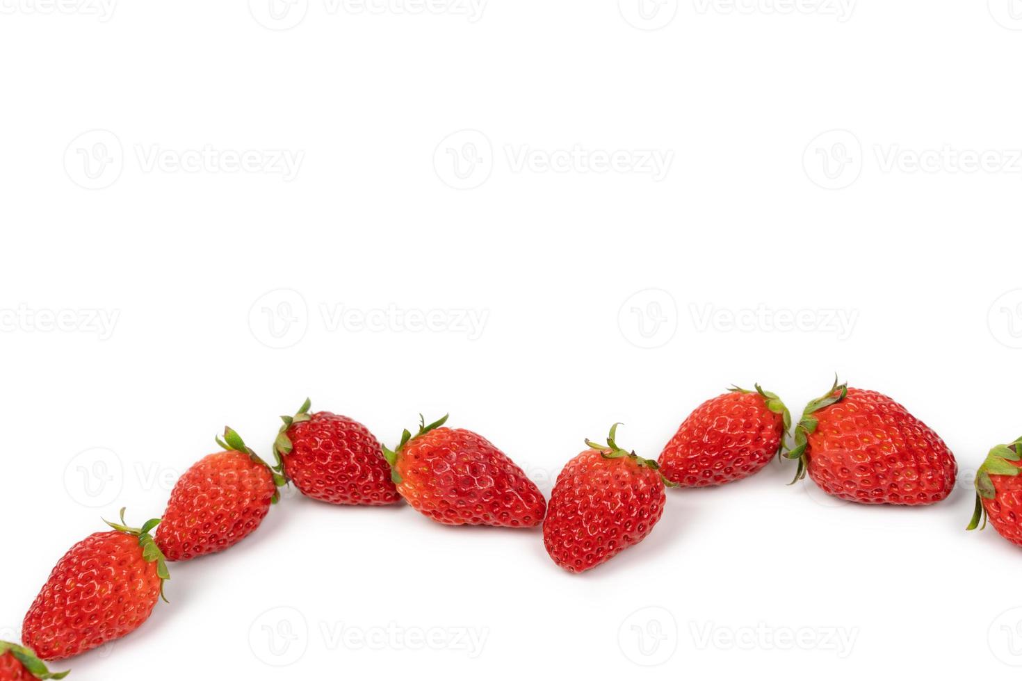 fresas de lujo frescas se interrumpen en el área del grupo con luz de estudio sobre el fondo blanco. foto