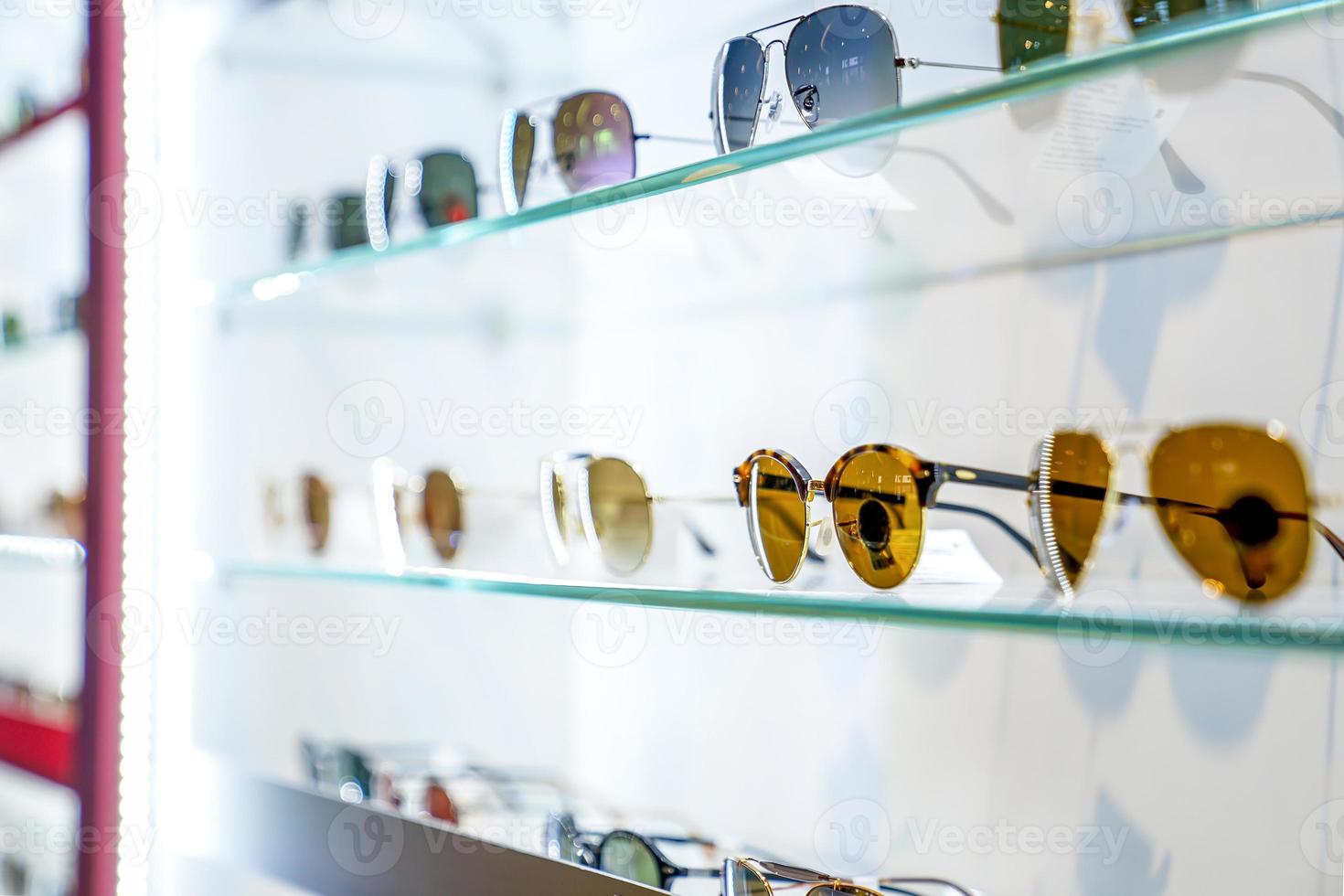 beautiful sun glasses on the display shelf in glass shop in department store Thailand. photo