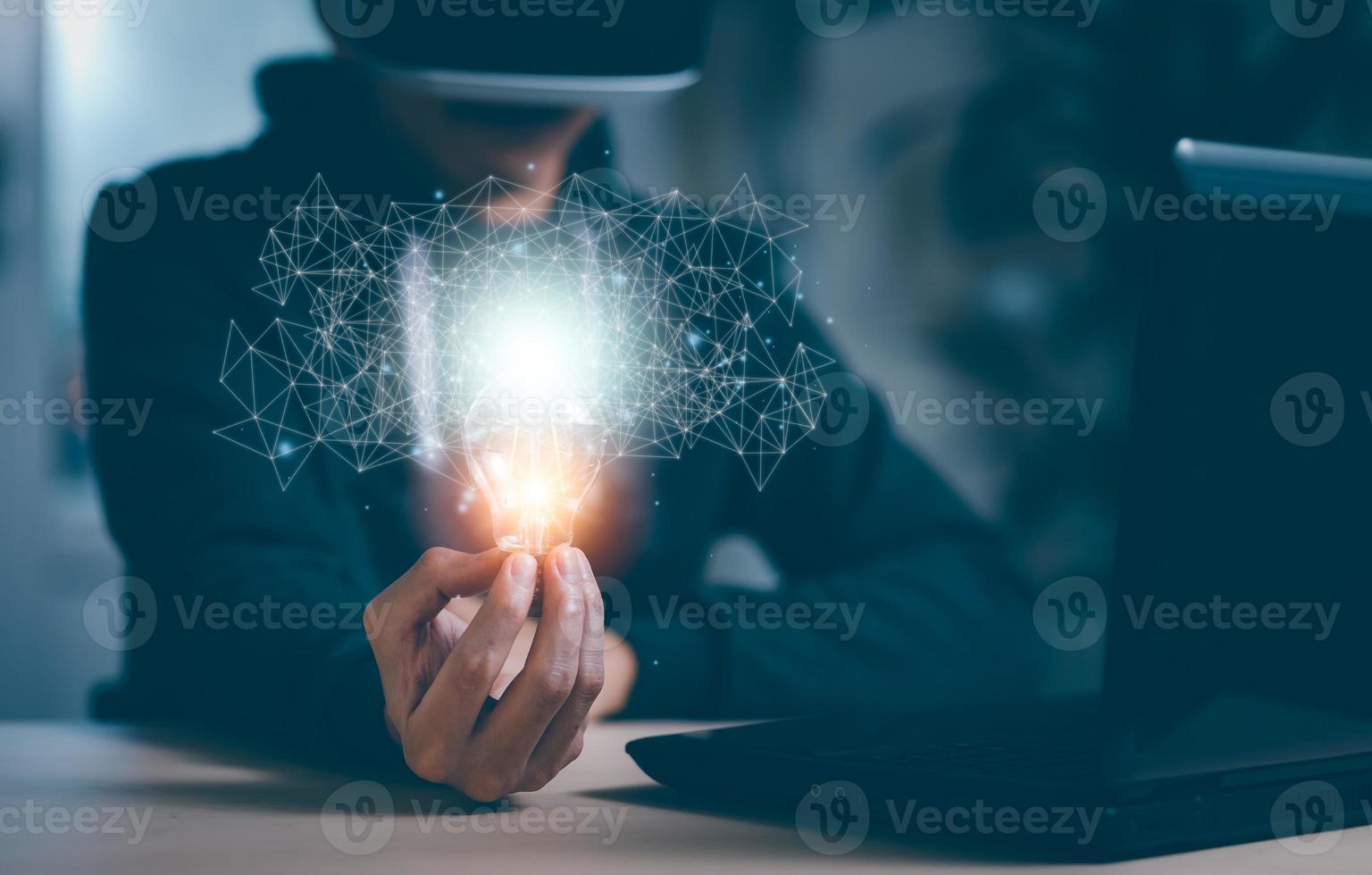 Man wearing VR glasses virtual and holding light bulb with icons and working on the desk, Creativity and innovation are keys to success.Concept  new idea and innovation with energy and power,Metaverse photo