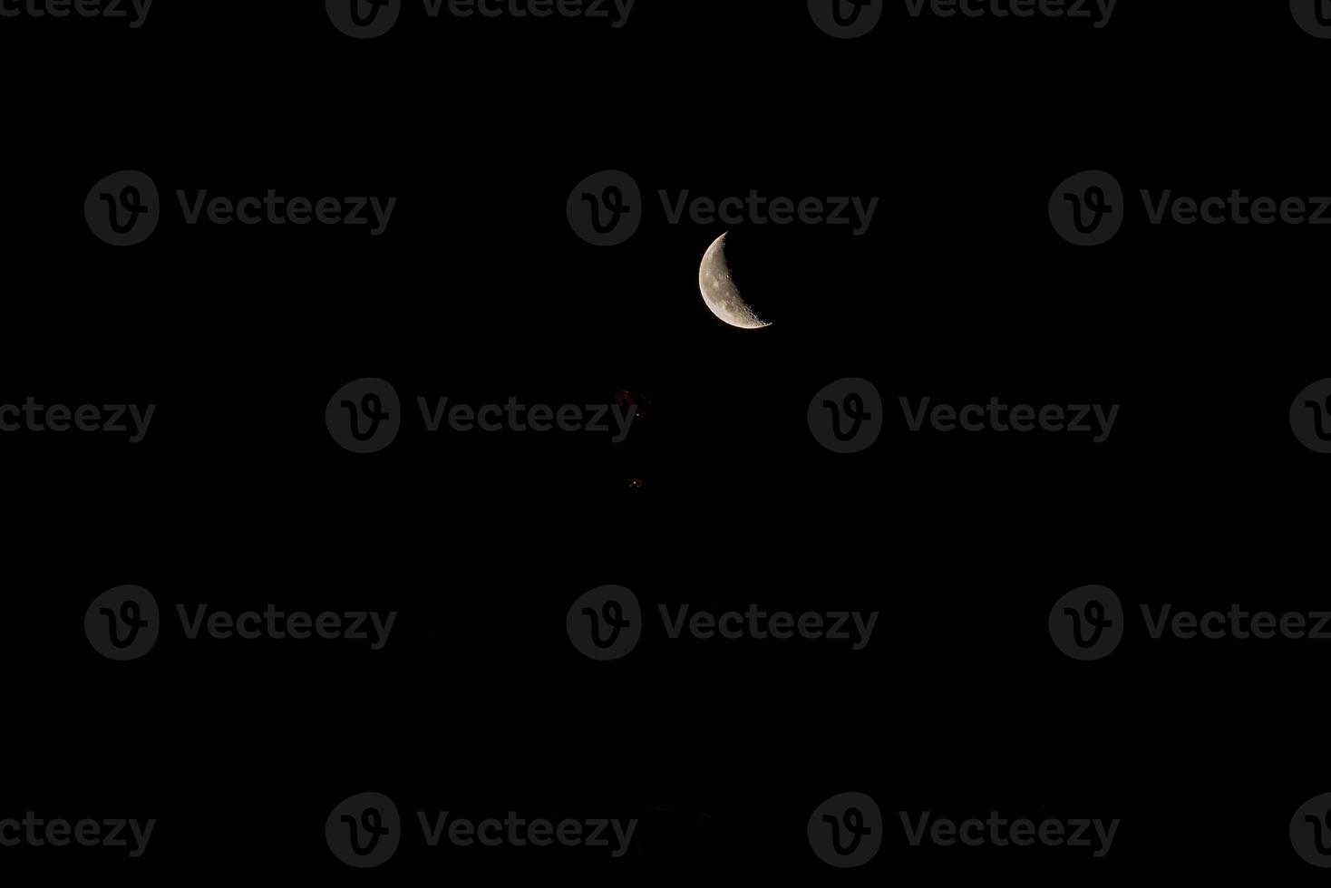 Beautiful orange quarter moon in the dark night sky photo