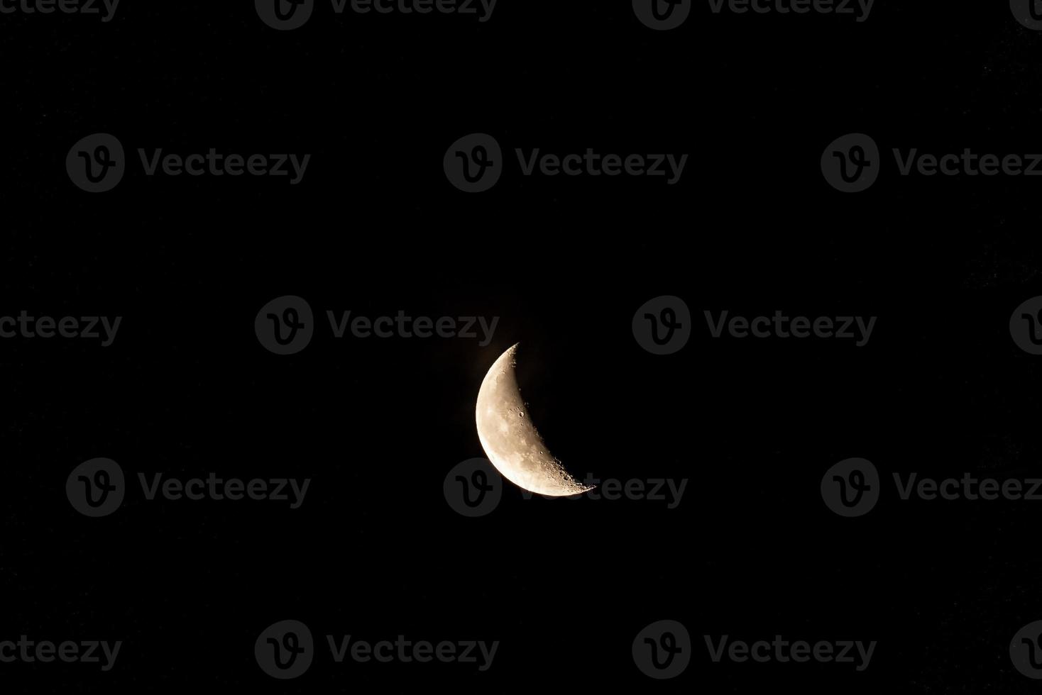 Beautiful orange quarter moon in the dark night sky photo