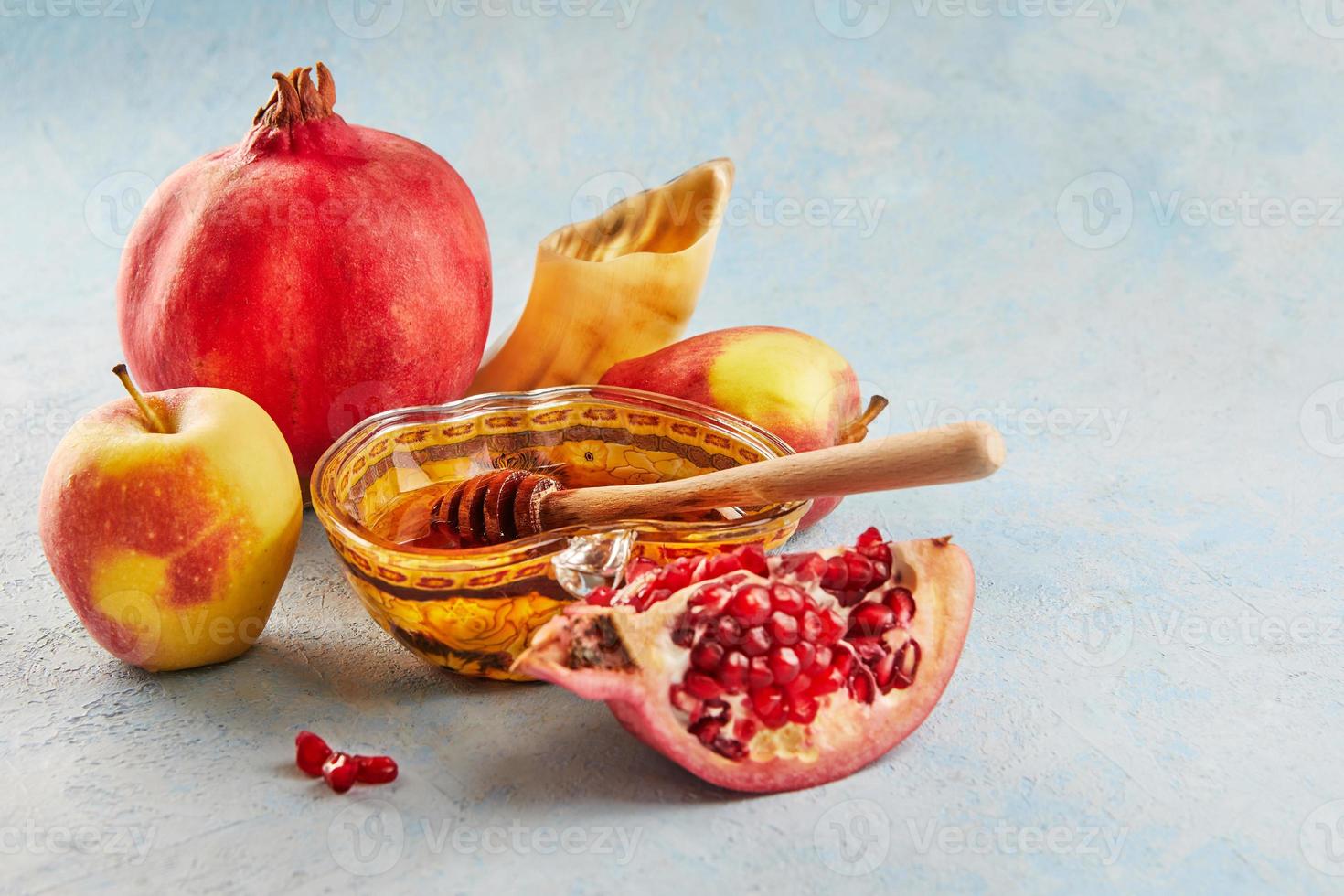 Rosh hashanah - jewish new year holiday concept. Apple-shaped bowl with honey, apples, pomegranates, a shofar are traditional symbols of the holiday photo